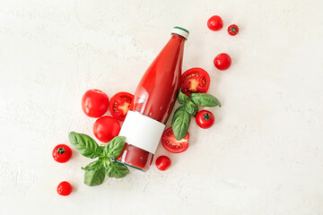 Bottle of tasty tomato juice on light background