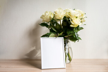 Portrait white frame mockup on table.Modern vase with rosesScandinavian interior
