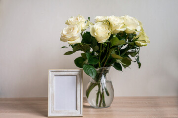 Portrait white frame mockup on table.Modern vase with rosesScandinavian interior