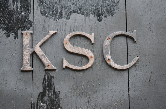 Old Wooden Door with Rusty Metal Letters 'KSC' in Close Up