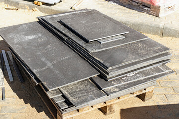 Porcelain stoneware tiles on a pallet at a construction site. Remains of tiles after laying the...
