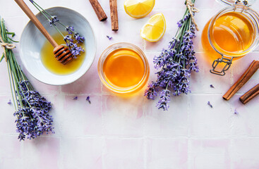 Jars and bowl with honey and fresh lavender flowers