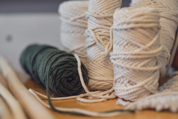 Balls of white yarn and rustic sticks on table. Good for macrame and handicrafts banners. natural decoration concept.
