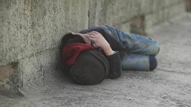 young homeless boy sleeping on the bridge, poverty, city, street