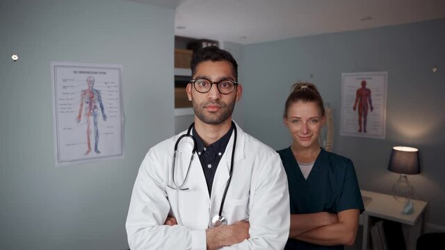 Mixed race male and female doctors standing in office