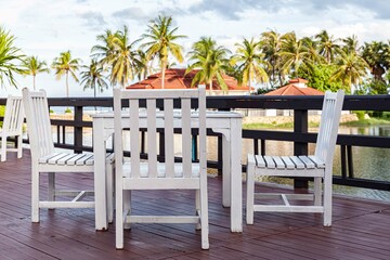 White wooden dining table by the pool inside the resort