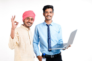 Indian bank officer or corporate government employee showing some information to farmer in laptop.