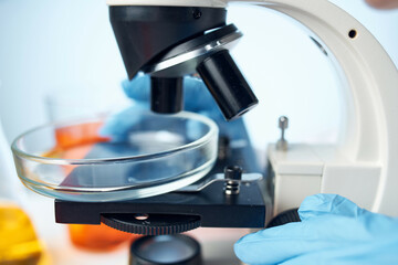 female laboratory assistant looking through a microscope biotechnology science research