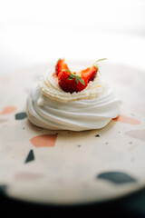Sweet dessert, Pavlov's cake with butter cream and strawberries. Soft focus background, a place for text .