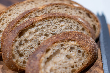 Fresh sliced bread on wooden board in kitchen