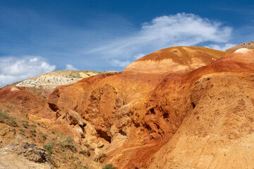 rocks made of colored clay against the backdrop of a beautiful blue sky