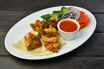 roasted chicken kebab with onion and sauce on a plate