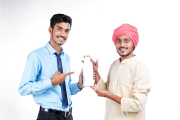 Young indian agronomist giving bottle to farmer on white background.