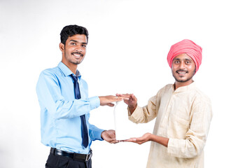 Young indian agronomist giving bottle to farmer on white background.