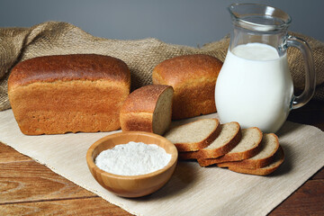 jug with milk and sliced traditional bread on wooden table