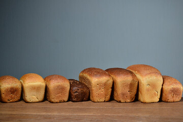 Assortment of baked bread on wooden table with dark background