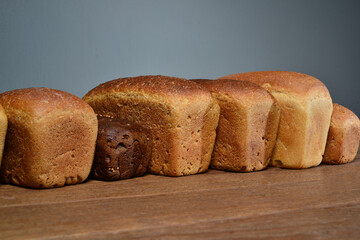 Assortment of baked bread on wooden table with dark background