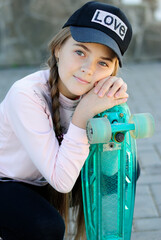 beautiful teenage girl with long hair in blue glasses and a plaid shirt on a skateboard