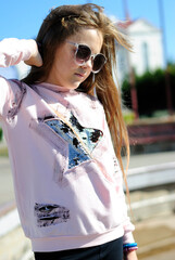 beautiful teenage girl with long hair wearing blue glasses and a plaid shirt portrait
