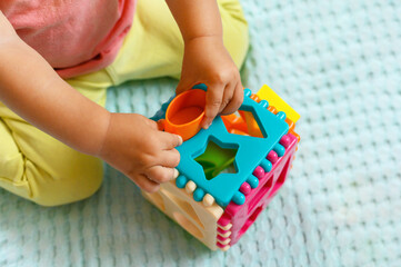 The child collects a multicolored sorter. Educational logic toy for kid's