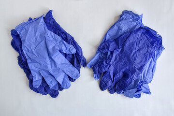 New blue medical latex gloves on light background. Disposable rubber medical gloves. Virus protection remedies. Top view. Close-up. Copy space. Selective focus.