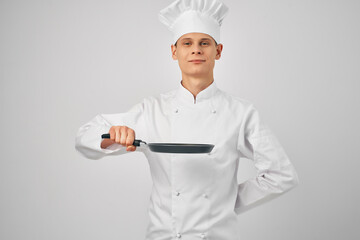 a man in a chef's uniform a frying pan in hand cooking food in the kitchen
