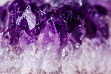 Macro mineral stone purple amethyst in crystals on a white background