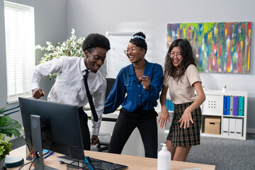 Dance at work, office, break from duties, company party, two girls and a man in a shirt and tie dancing together, fooling around, laughing, smiling, relieving stress, music playing from the computer