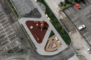 view of the playground from above. an empty playground in summer. Benches, swings, metal structures.