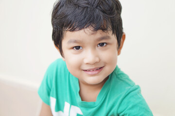 Cute Asian child little Thai boy 4 year old smile make a happy face concept.                               