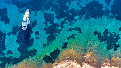 Aerial drone top down ultra wide photo of luxury yacht anchored in tropical exotic island bay with...