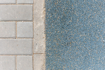 the border of a pedestrian path and a modern rubber floor covering.