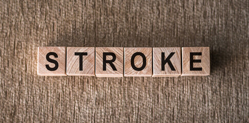 Fototapeta premium STROKE word written on wooden blocks on a brown background.