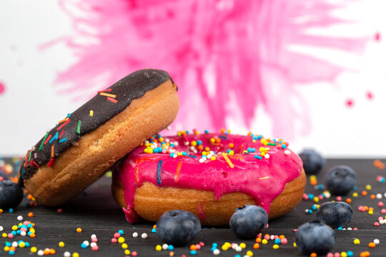 Creative sweet food. Bright donuts with multi-colored sprinkles on a colorful background.