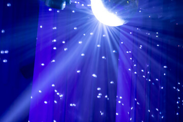 Fototapeta na wymiar Stage ball spotlight with small white spots on a blue background.