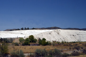 Natural Pamukkale travertine pools and terraces view from Pamukkale, Denizli, Turkey. Cotton castle at sunny bright day.
