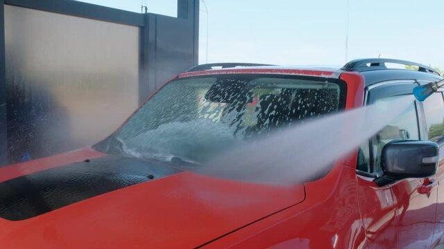 Washing the car with high pressure water. Car in foam at a car wash