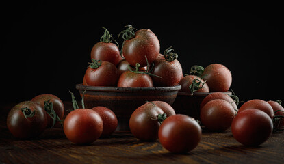 A lot of ripe juicy tomatoes on a black background. Black tomatoes.