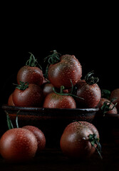 A lot of ripe juicy tomatoes on a black background. Black tomatoes are cumato.