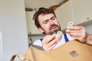 Plumber from the emergency repair service checks spare parts