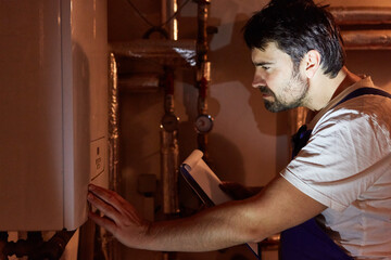Obraz na płótnie Canvas Heating fitter with checklist checks gas heating