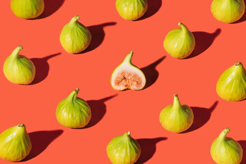 Pattern made of fresh organic mediterranean figs on bright terracotta background. Modern design arrangement.