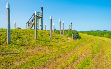 Fototapeta premium Unesco protected outline of an ancient former harbor of an island swallowed by reclaimed new land under a blue sky in summer, Noordoostpolder, Schokland, Flevoland, Netherlands, August 23, 2021