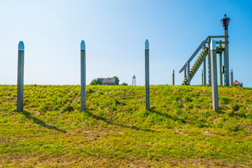 Fototapeta na wymiar Unesco protected outline of an ancient former harbor of an island swallowed by reclaimed new land under a blue sky in summer, Noordoostpolder, Schokland, Flevoland, Netherlands, August 23, 2021