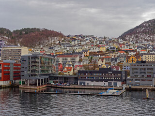Fototapeta na wymiar Apartments, Houses and Maritime Buildings all mixed up with one another on the waterfront of Bergen Port on a wintry day in April.