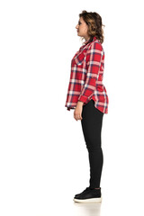 Side view of young casual woman standing isolated on white background.