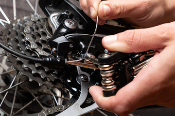 tightening the gear shift cable on a bicycle with multitool.