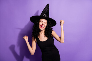 Photo of young beautiful cheerful excited witch girl raise fists in victory success isolated on purple color background