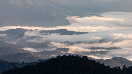 Aerial view over mountain range covered by clouds.