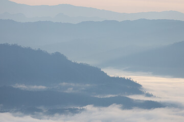 Aerial view over mountain range covered by clouds.